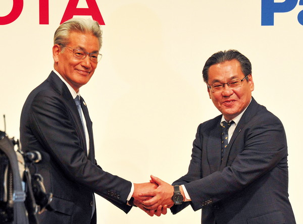 両社の代表ががっちり握手